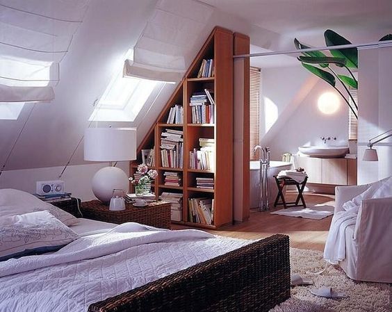 an attic bedroom with a bed, desk and bookcase in the corner is shown