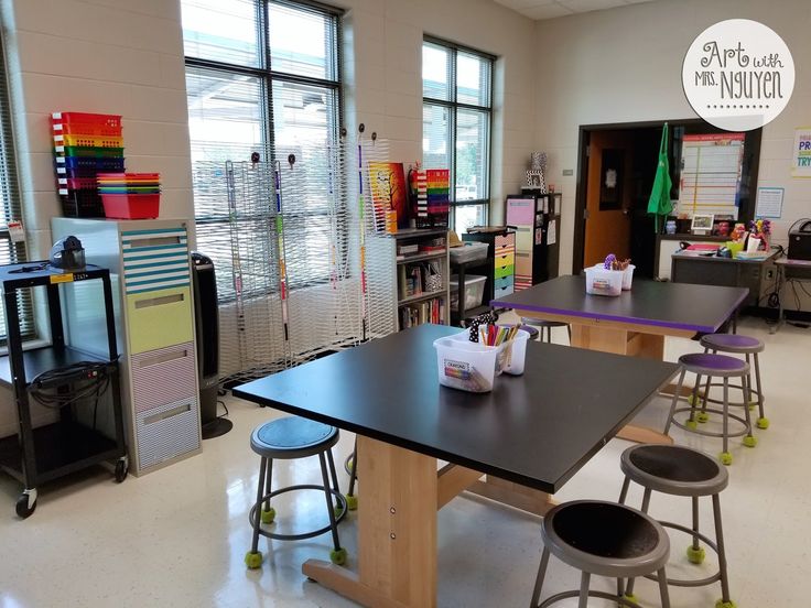 an empty classroom with tables and chairs