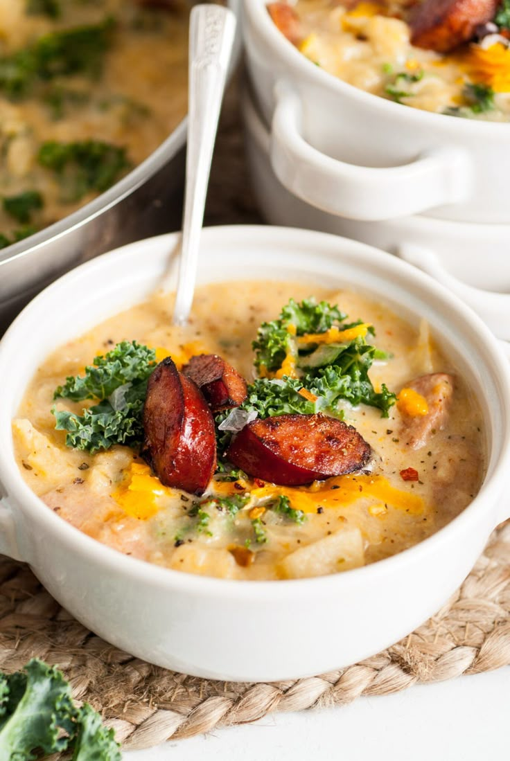 there is a bowl of soup with sausage and broccoli