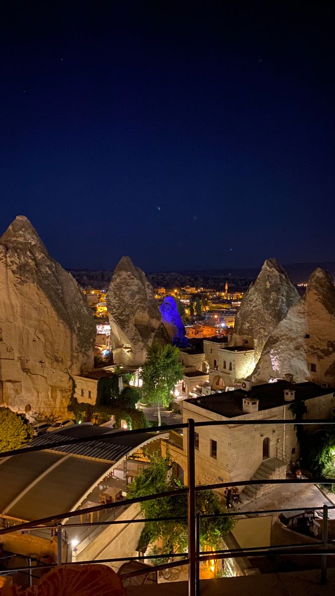 night view of the city with mountains and buildings in the foreground, lit up by street lights