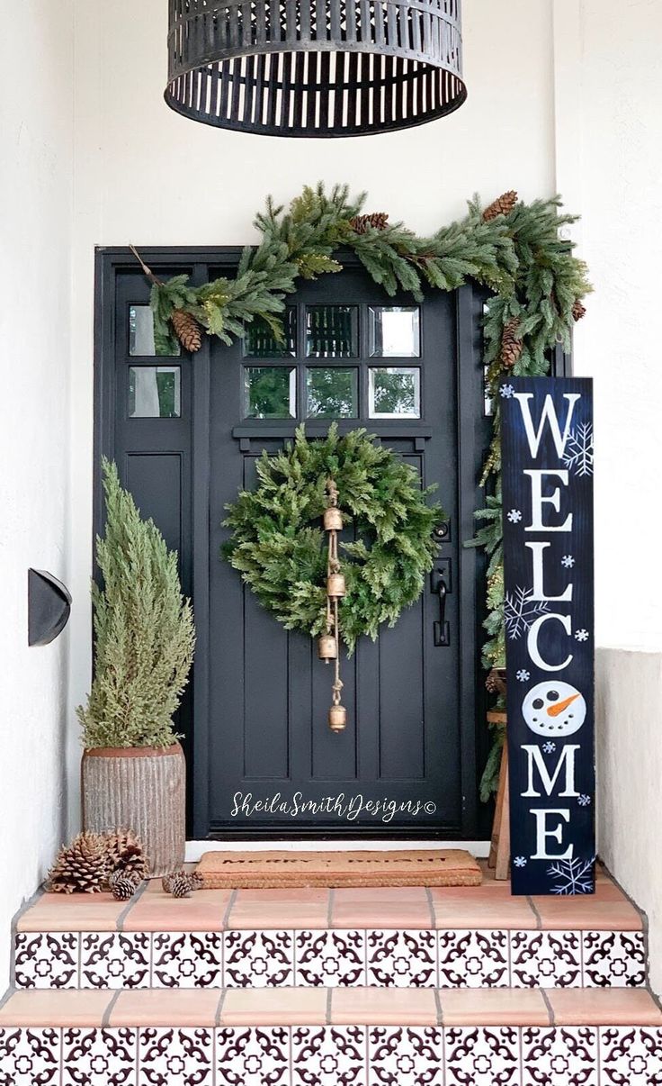 the front door is decorated with wreaths and pine cones