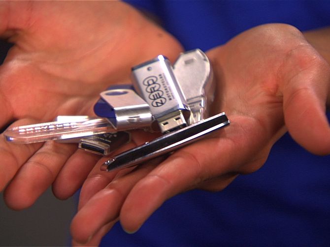 a person holding several different types of cell phones in their hands, one is silver and the other is black