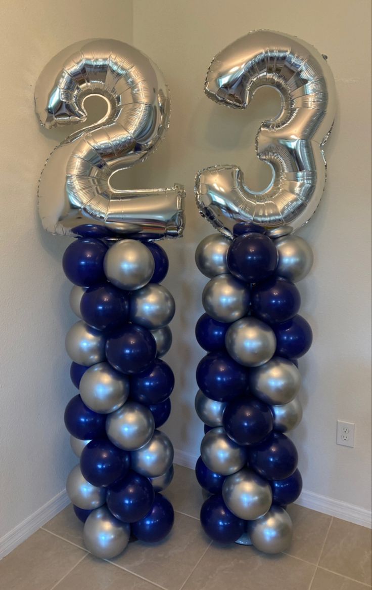 two silver and blue balloons in the shape of numbers