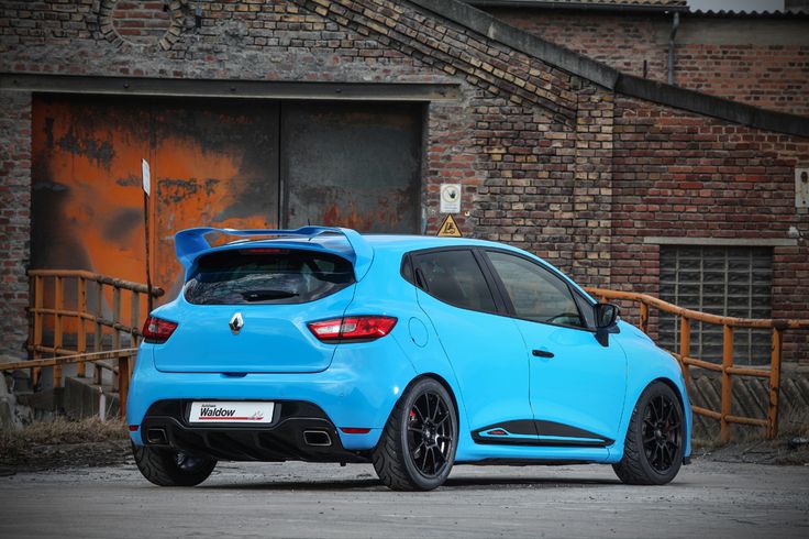 a blue car parked in front of a brick building