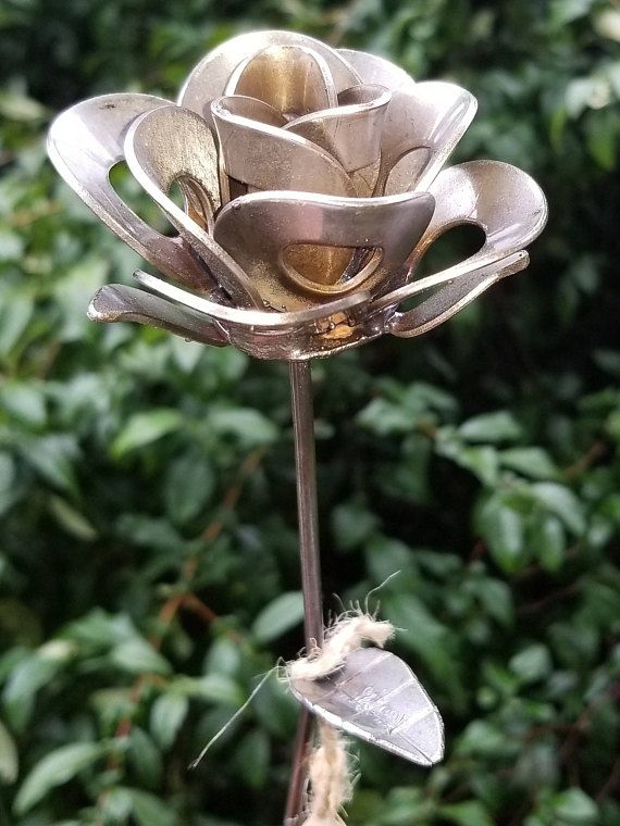 there is a metal flower with leaves on it