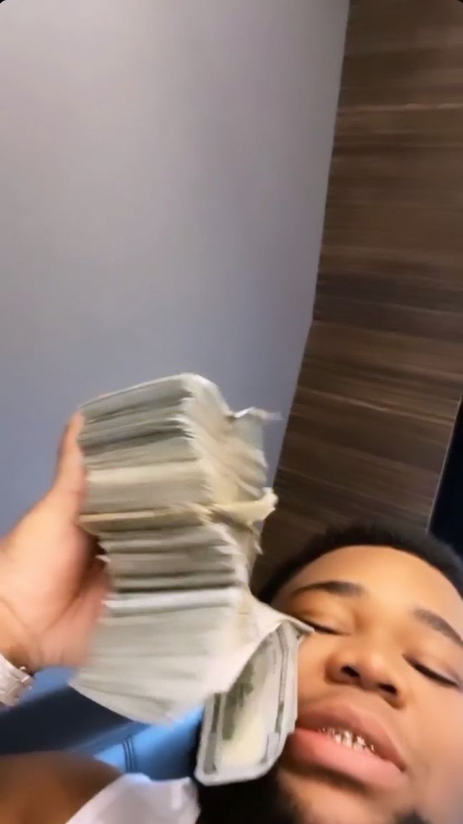 a man is holding stacks of money up to his face