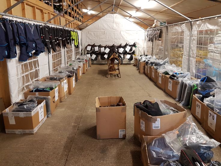 the inside of a warehouse with boxes and clothes