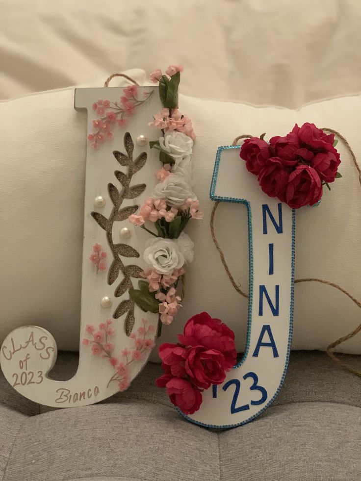 a decorative pillow with flowers on it and the letter j next to it that is decorated