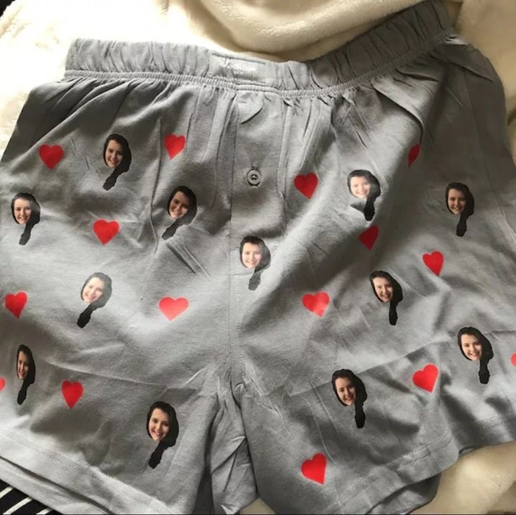 a pair of shorts with pictures of people on them and hearts drawn on the side