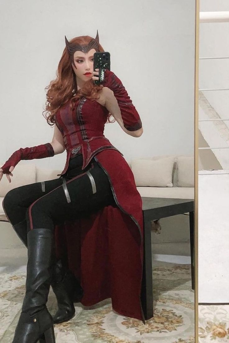 a woman dressed in red and black is taking a selfie with her cell phone