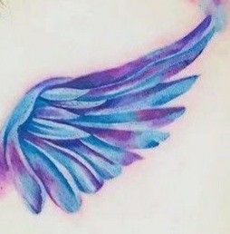 an angel wing tattoo on the back of a woman's shoulder