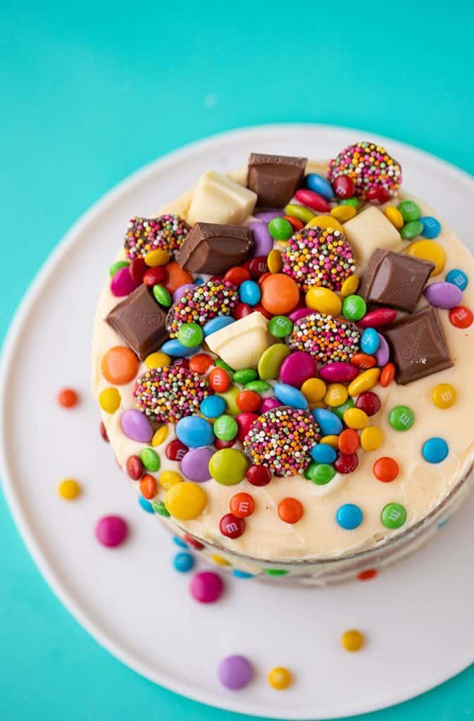 a white plate topped with a cake covered in sprinkles and candies