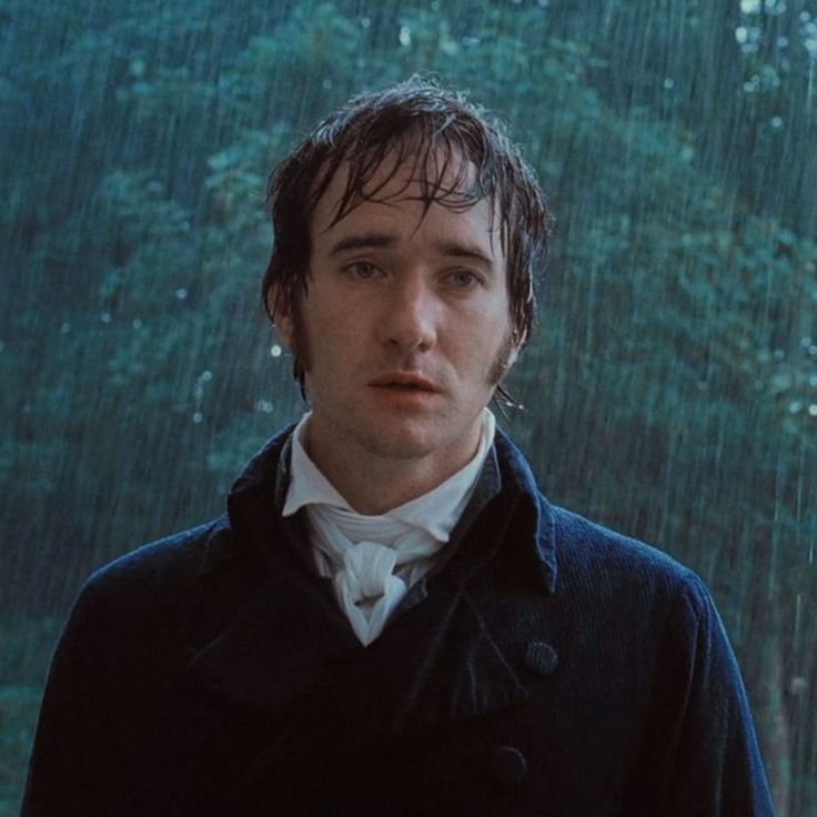 the young man is standing in front of an open window with rain pouring down on him