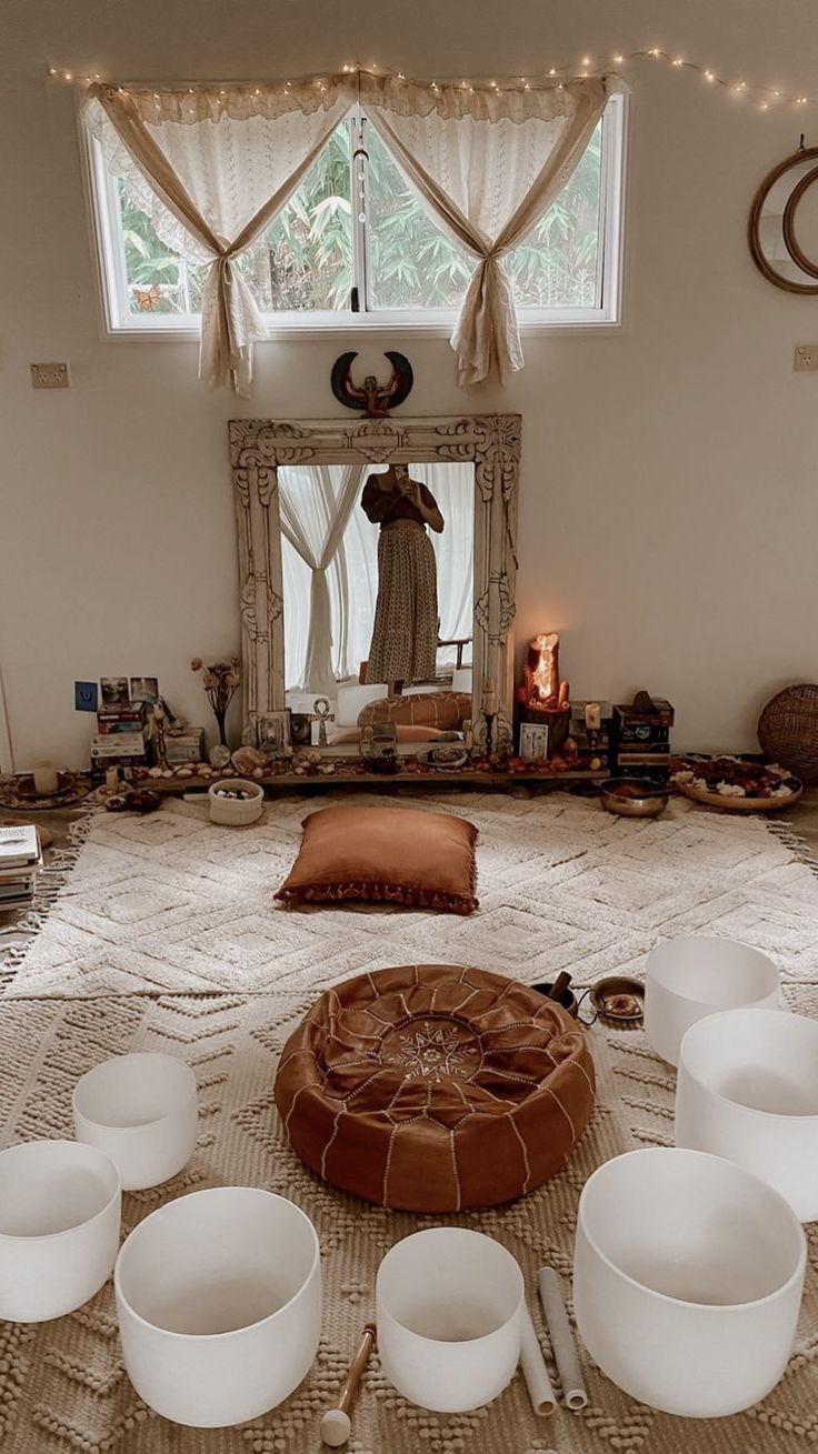 there are bowls and cups on the floor in front of a large mirror with lights