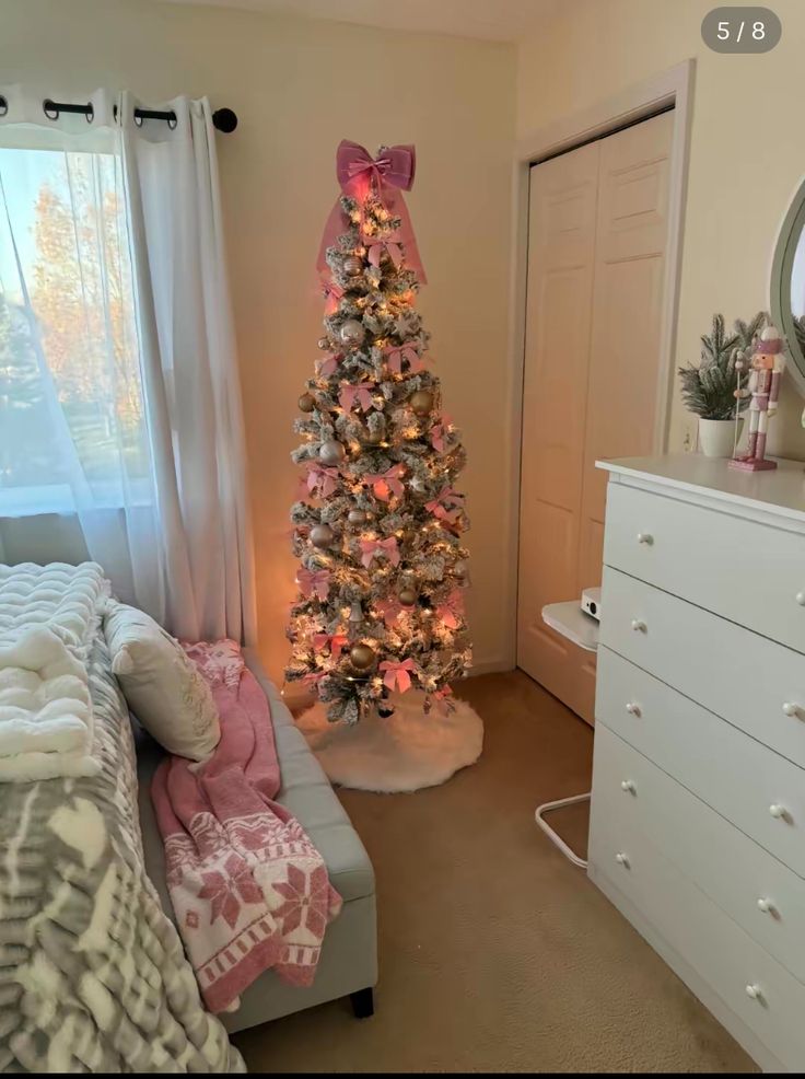 a decorated christmas tree in the corner of a bedroom