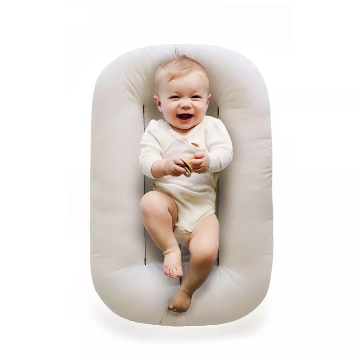 a baby is sitting in an infant pillow