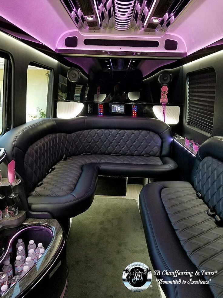 the inside of a limo with black leather seats and purple lighting on it's ceiling