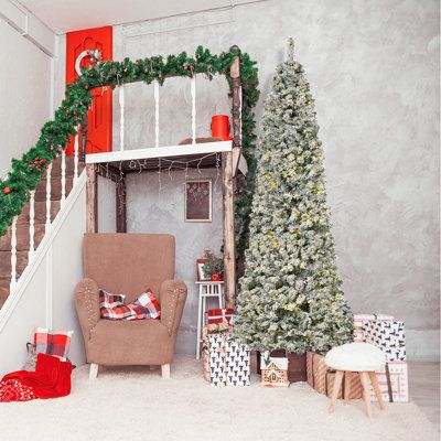 a living room decorated for christmas with presents on the floor and a tree in the corner