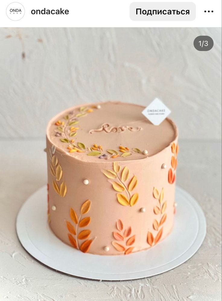 a pink cake with gold leaves on it