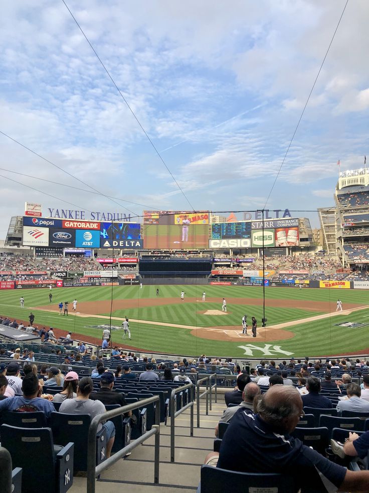 a baseball game is being played in a stadium with people sitting on the bleachers