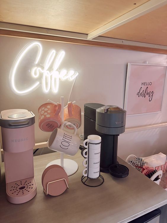 a coffee bar with neon sign and cups on the counter top, along with other items