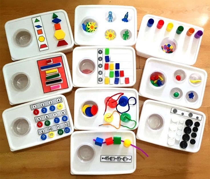 several trays filled with different types of crafting materials on top of a wooden table