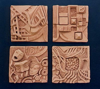 four carved tiles with different designs on them