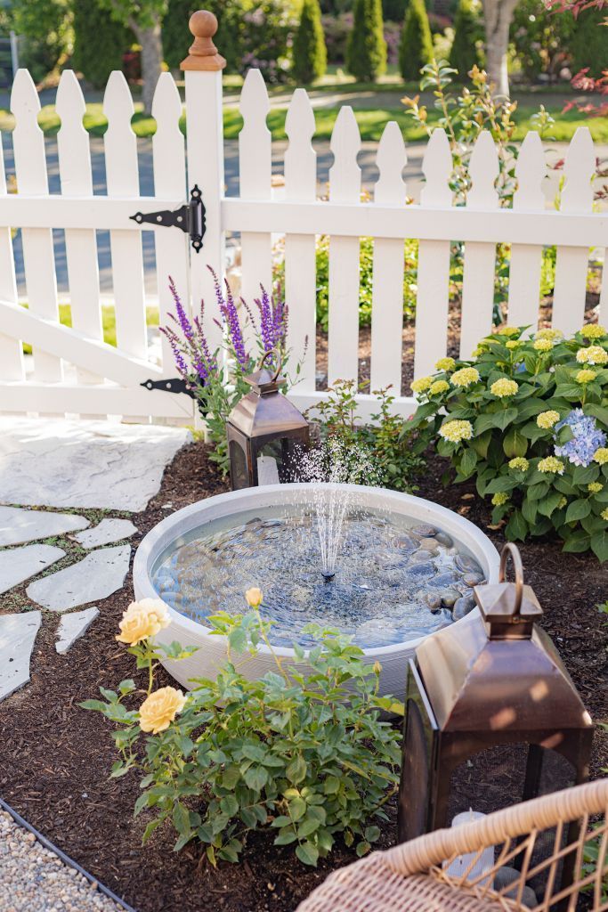 a water fountain in the middle of a garden