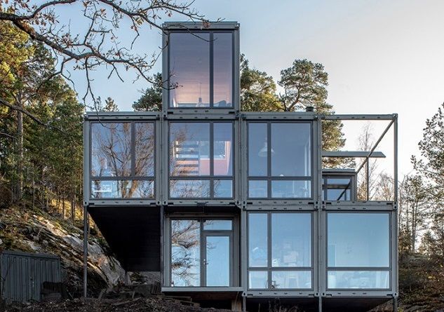 a house made out of shipping containers sitting on top of a hill