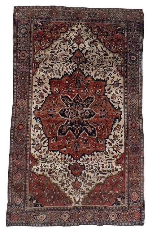 an antique persian rug with red and beige colors