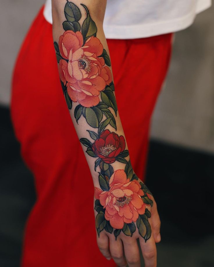 a woman's arm with flowers on it and the words tattoo written in french