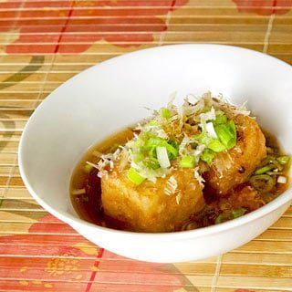 a white bowl filled with food on top of a wooden table