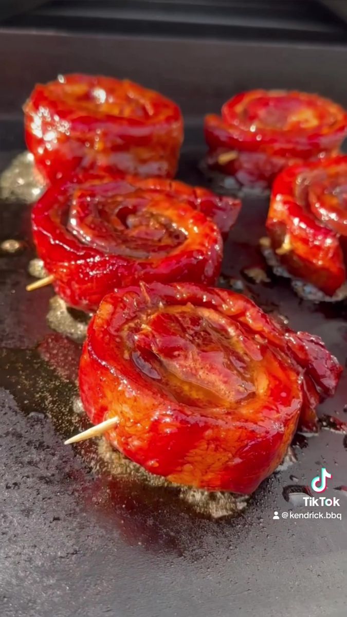 some food is cooking on a grill with toothpicks sticking out of it's middle