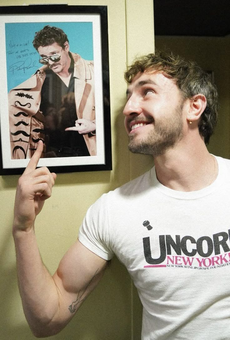 a man with his finger up in front of a poster