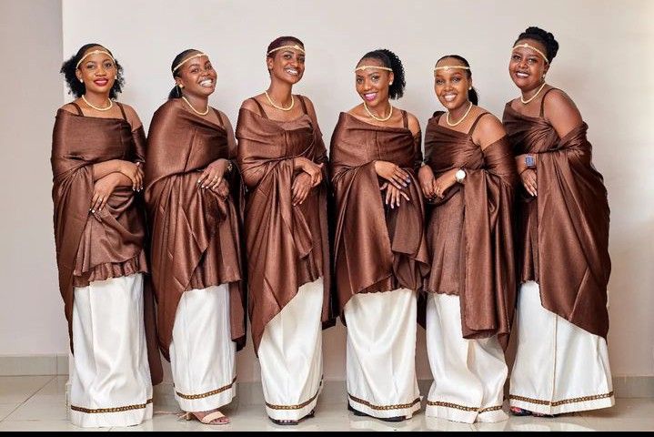 four women in brown and white dresses posing for the camera