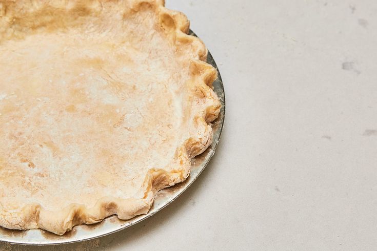 an uncooked pie sitting on top of a metal pan next to a knife