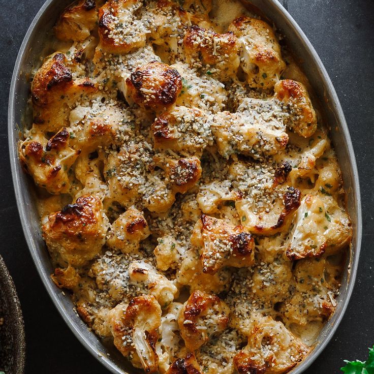 a casserole dish with meat and cheese in it on a black counter top