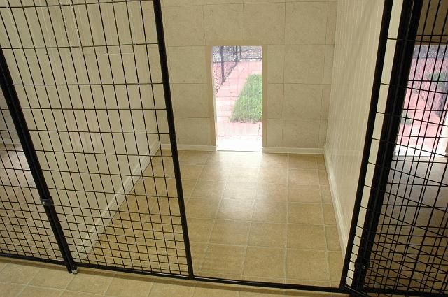 an open door in a room with tiled flooring and black iron bars on the doors