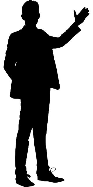 the silhouette of a man in a suit and tie is pointing his finger at something