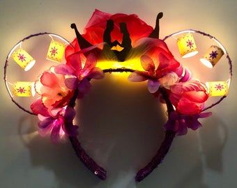 a light up mickey mouse ears with flowers on the ears and lights attached to it