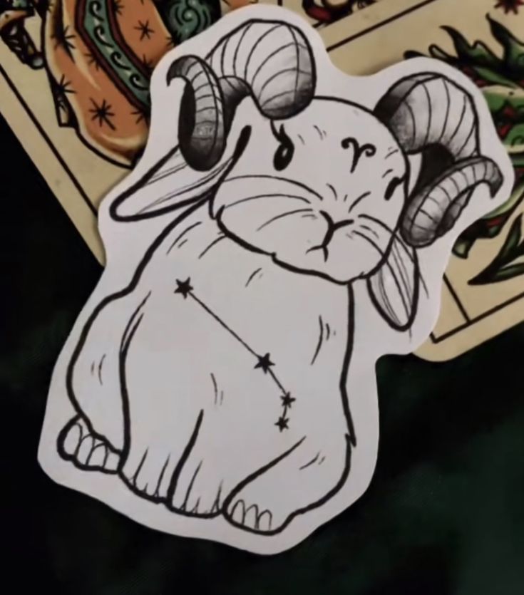 a sticker with an image of a ram on it's head and zodiac signs in the background