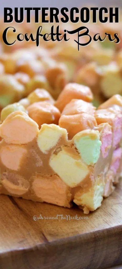 a wooden cutting board topped with a slice of butterscotch confetti bars