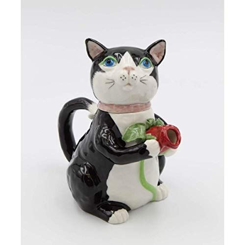 a black and white cat figurine holding a rose