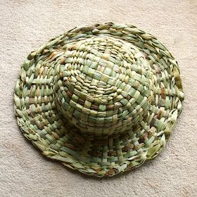 a woven hat sitting on top of a white carpet