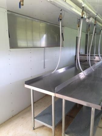 an empty room with stainless steel benches in it