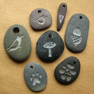 six stone pendants with different designs and animals on them, sitting on a table