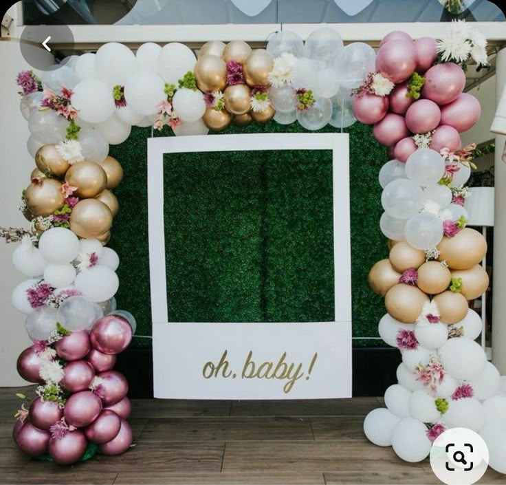 a baby's first birthday photo frame with balloons and greenery in the background