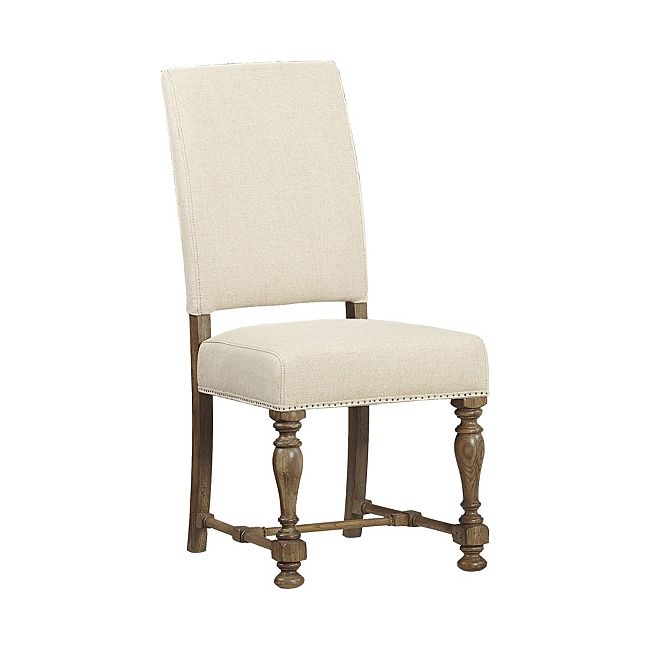 an upholstered chair with wooden legs and a white fabric seat pad on the back