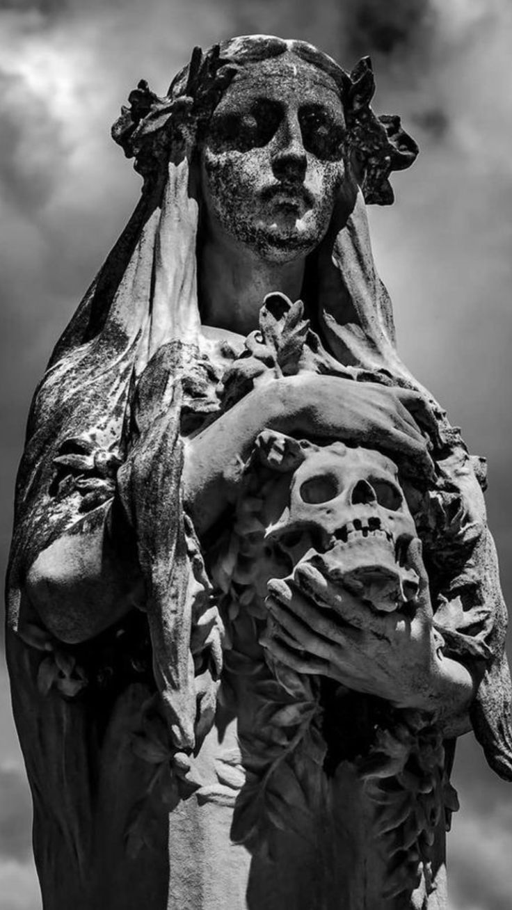 black and white photograph of a statue holding a skull