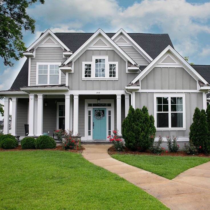 a gray house with white trim and blue door